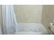 A large bathtub features a whirlpool and travertine tile surround at 1613 Beacon Valley Dr, Raleigh, NC 27604