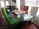 Stylish dining area with a glass table, colorful chairs, and an open view to the living room at 1613 Beacon Valley Dr, Raleigh, NC 27604