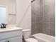 Well-lit bathroom featuring a tiled shower, modern vanity, and white toilet at 1636 Raven Falls Dr, Wendell, NC 27591
