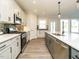 Well-lit kitchen featuring stainless steel appliances and a spacious island with quartz countertops at 1636 Raven Falls Dr, Wendell, NC 27591
