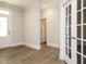 Living room showcasing light-colored walls, wood-look flooring, and a glass paneled door at 1636 Raven Falls Dr, Wendell, NC 27591