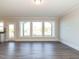 Bright, neutral living area featuring a back door and a wall of windows at 1636 Raven Falls Dr, Wendell, NC 27591