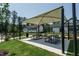 Outdoor picnic area with sunshades, picnic tables, landscaping, and grassy lawn at 1636 Raven Falls Dr, Wendell, NC 27591