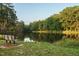 Scenic community pond with park bench surrounded by mature trees and green landscape at 1636 Raven Falls Dr, Wendell, NC 27591
