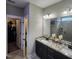 Elegant bathroom featuring a double vanity, granite countertop, and a walk-in closet access at 1643 Wimberly Rd, Apex, NC 27523