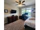 Bedroom with a bed, desk and chair setup, with wall-mounted TV, natural light, and neutral decor at 1643 Wimberly Rd, Apex, NC 27523