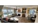 Bright living room with a fireplace, built-in shelving, large windows, and wood floors at 1643 Wimberly Rd, Apex, NC 27523