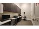 A well-lit office area features sleek dark cabinets, a spacious desk, and modern computer setups for convenient work at 1643 Wimberly Rd, Apex, NC 27523