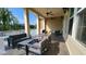 A covered outdoor patio with stylish furniture and ceiling fans offers a relaxing view of the pool and green trees at 1643 Wimberly Rd, Apex, NC 27523