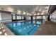 Bright indoor pool with marked lanes, large windows, and lounge chairs around the perimeter at 1643 Wimberly Rd, Apex, NC 27523