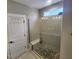 Modern shower with glass door, neutral tile, and a pebble floor at 1643 Wimberly Rd, Apex, NC 27523