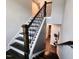 Elegant staircase with dark wood steps, white risers, and black iron railings at 1643 Wimberly Rd, Apex, NC 27523