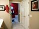 Hallway view to bathroom area featuring tub with red accent wall and double door closet at 2002 Clyde Bank Ct, Cary, NC 27511
