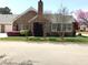 Brick home featuring a well-maintained lawn, mature trees, and an attached garage for convenient parking at 2002 Clyde Bank Ct, Cary, NC 27511