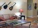 Cozy living room featuring hardwood floors, a comfortable couch, a glass coffee table, and decorative guitars on the wall at 2002 Clyde Bank Ct, Cary, NC 27511