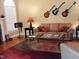 Cozy living room featuring a fireplace, hardwood floors, a comfortable couch, and decorative guitars on the wall at 2002 Clyde Bank Ct, Cary, NC 27511