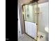Shower with sliding gold trimmed glass doors, towel rack, and shower head at 2002 Clyde Bank Ct, Cary, NC 27511