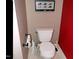 Toilet in bathroom with framed art, and a red accent wall at 2002 Clyde Bank Ct, Cary, NC 27511