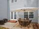 The back patio includes brick steps to a table setting with an umbrella and wicker chairs at 2067 White Pond Ct, Apex, NC 27523