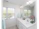 Bright bathroom with double sinks, large mirror, and a window with a view at 2067 White Pond Ct, Apex, NC 27523