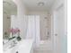 Clean bathroom with tub and shower, white shower curtain and a floral arrangement at 2067 White Pond Ct, Apex, NC 27523