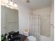 Well-lit bathroom features a shower with a curtain, a toilet, and a sink with a dark countertop at 2067 White Pond Ct, Apex, NC 27523
