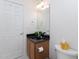 This bathroom has a sink with a dark countertop and a white toilet with paper products on top at 2067 White Pond Ct, Apex, NC 27523