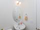 Bright bathroom featuring a white sink, oval mirror, and modern lighting fixture at 2067 White Pond Ct, Apex, NC 27523