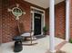 Cozy front porch featuring a rocking chair, decorative brickwork, and a welcoming entrance at 2067 White Pond Ct, Apex, NC 27523