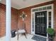 Inviting front porch with brick accents, decorative door, and a cozy rocking chair at 2067 White Pond Ct, Apex, NC 27523
