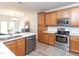 Open-concept kitchen featuring wooden cabinets, stainless steel appliances, and a kitchen island at 2067 White Pond Ct, Apex, NC 27523