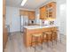 Open kitchen with stainless steel refrigerator, island with seating, and light wood flooring at 2067 White Pond Ct, Apex, NC 27523