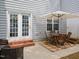 Back patio has brick steps that lead to the door and windows with an outdoor table setting at 2067 White Pond Ct, Apex, NC 27523