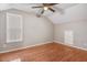 Bedroom with hardwood floors, ceiling fan, and large windows offering plenty of natural light at 2120 Castle Pines Dr, Raleigh, NC 27604