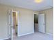 Carpeted bedroom featuring ensuite bathroom and nearby closet with neutral walls and white trim at , Raleigh, NC 27604