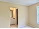 Carpeted bedroom with ensuite bath featuring a single vanity with bright lighting and a large mirror at , Raleigh, NC 27604
