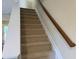 Carpeted staircase featuring a wooden handrail, leading to the upper level of the home at , Raleigh, NC 27604