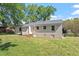 View of the home's backyard, with a well-maintained lawn and mature trees, showcasing outdoor space at 2304 Nelson St, Raleigh, NC 27610