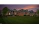Charming brick home featuring a manicured lawn and lovely landscaping with a beautiful sunset backdrop at 2326 Marlow Dr, Burlington, NC 27215