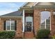 Inviting front entrance with brick facade, decorative wreath, covered porch, and beautiful sidelight windows at 2326 Marlow Dr, Burlington, NC 27215