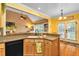 Bright kitchen with wood cabinetry, granite countertops, stainless appliances, and a view to the living room at 2326 Marlow Dr, Burlington, NC 27215