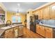 Bright kitchen with warm wood cabinets, stone countertops, and stainless steel refrigerator at 2326 Marlow Dr, Burlington, NC 27215