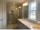 Bathroom featuring a frameless glass shower and single-sink vanity with a white countertop at 245 N Maple Walk Dr # 219, Garner, NC 27529