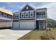 New construction home with a two-car garage, covered balcony, and blue horizontal siding at 245 N Maple Walk Dr # 219, Garner, NC 27529