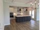 Modern kitchen featuring an island with seating, pendant lighting, and stainless steel appliances at 245 N Maple Walk Dr # 219, Garner, NC 27529