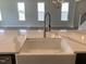 Close-up on modern kitchen sink with white countertops overlooking the living area at 245 N Maple Walk Dr # 219, Garner, NC 27529