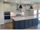 Modern kitchen with white cabinetry, a gray island, stainless steel appliances, and pendant lights at 245 N Maple Walk Dr # 219, Garner, NC 27529