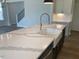 Kitchen island with a farmhouse sink, stainless steel appliances, and white countertops at 245 N Maple Walk Dr # 219, Garner, NC 27529
