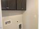 The laundry room has gray cabinets above the appliances and utility connections for washer and dryer at 245 N Maple Walk Dr # 219, Garner, NC 27529