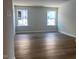 Bright, empty living room with hardwood floors and large windows providing natural light at 245 N Maple Walk Dr # 219, Garner, NC 27529
